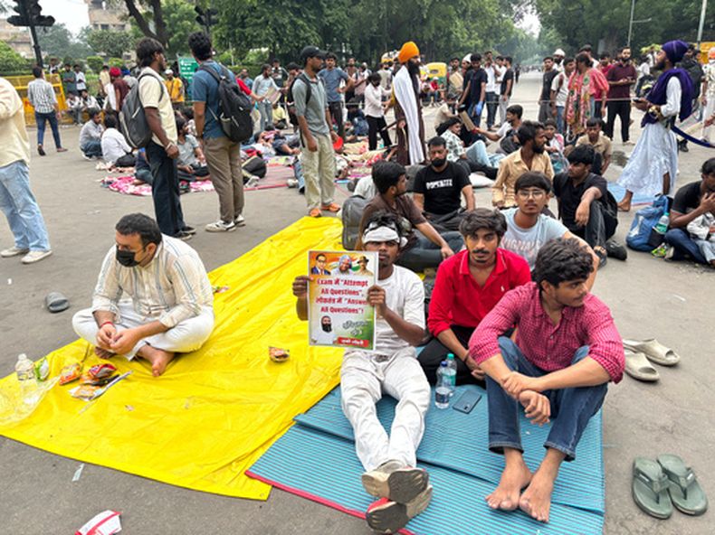 Un manifestante muestra un cartel con la frase En un examen intenta responder todas las preguntas, en una democracia responde todas las preguntas durante una protesta para reclamar reformas educativas, durante la movilización del Partido de las Cucarachas en Nueva Delhi, India, el 24 de julio de 2026. (AP Foto/Shonal Ganguly)