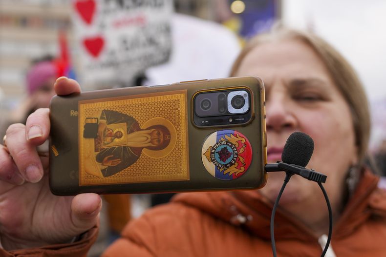 Una mujer graba un video con su smartphone durante una protesta originada tras el derrumbe de una marquesina de hormigón en una estación de tren de la ciudad septentrional de Novi Sad el 1 de noviembre de 2024, en la que murieron 15 personas, en Kragujevac, Serbia, el sábado 15 de febrero de 2025. (AP Foto/Darko Vojinovic)