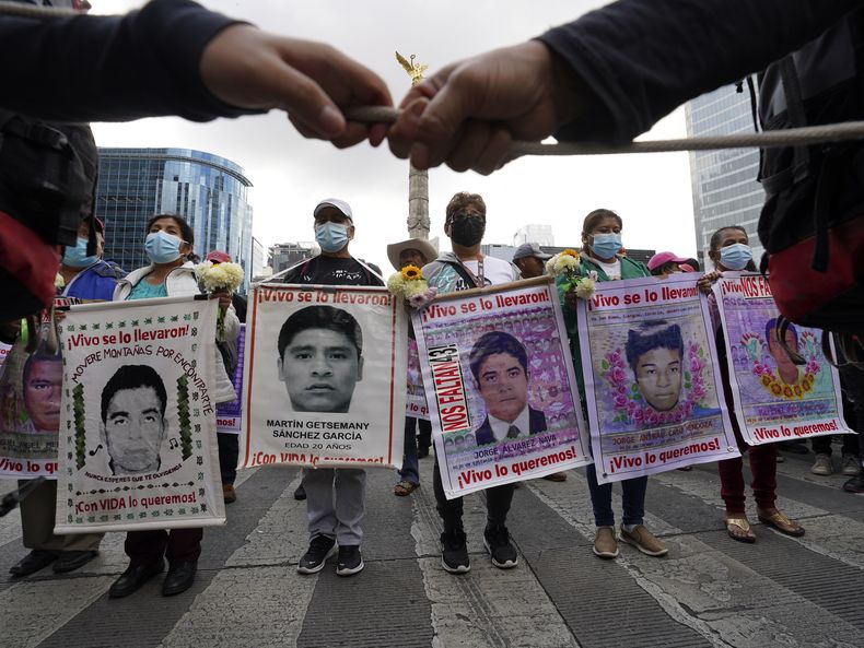 ARCHIVO - Familiares y compañeros de clase de los 43 estudiantes de colegio desaparecidos de Ayotzinapa marchan en Ciudad de México el 26 de septiembre de 2022 en el aniversario de la desaparición en Iguala, en el estado de Guerrero. Ocho militares vinculados a la desaparición de los estudiantes en 2014 fueron detenidos y permanecen en una prisión militar a la espera de que un juez determine si los procesados penalmente, según informó un mando del Ejército el jueves 22 de junio de 2023. (AP Foto/Marco Ugarte, Archivo)