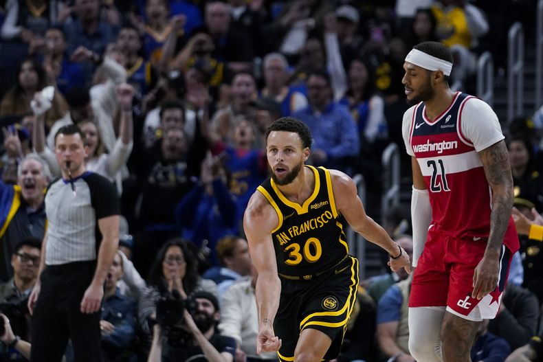 Stephen Curry, base de los Warriors de Golden State, festeja luego de atinar un triple en el encuentro del viernes 22 de diciembre de 2023, ante los Wizards de Washington (AP Photo/Godofredo A. Vásquez)