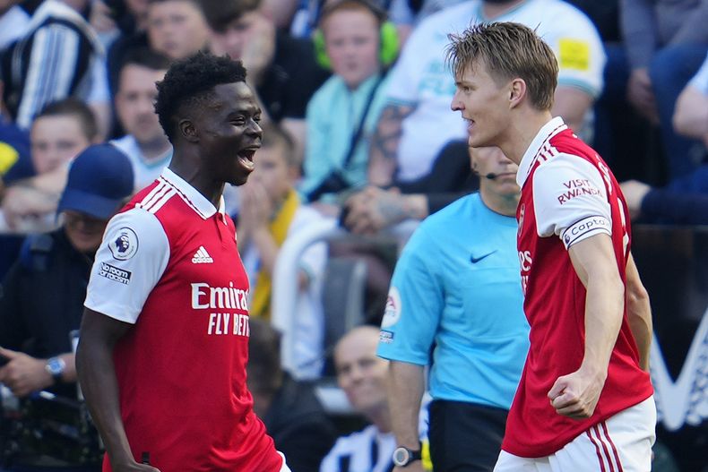 Martin Odegaard (derecha) celebra con Bukayo Saka tras anotar el primer gol de Arsenal contra Newcastle en la Liga Premier, el domingo 7 de mayo de 2023. (AP Foto/Jon Super)