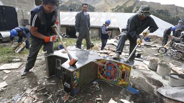 americateve | Trabajadores usan mazas para destruir m&aacute;quinas tragamonedas que fueron confiscadas tres a&ntilde;os atr&aacute;s a casas de juego ilegales el viernes 28 de octubre de 2014 en La Paz, Bolivia. (AP foto/Juan Karita)