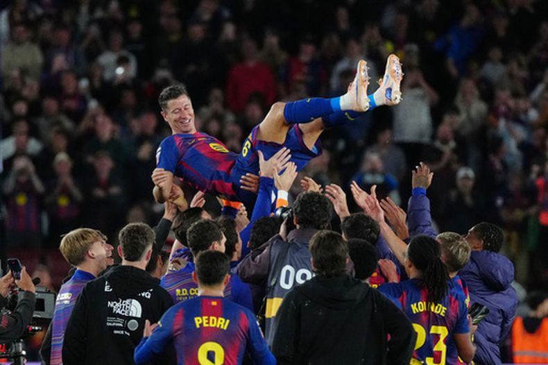 ARCHIVO - Robert Lewandowski, arriba, es arrojado al aire por sus compañeros de equipo del Barcelona después de su último partido con el equipo español en La Liga de España entre FC Barcelona y Real Betis, el 17 de mayo de 2026, en Barcelona, España. (AP Foto/Joan Mateu Parra, Archivo)