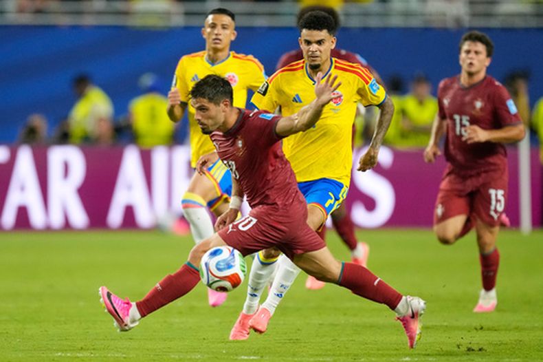 El colombiano Luis Diaz (7) y el portugués Pedro Neto (18) pugnan por el balón en el partido del Grupo K del Mundial, el sábado 27 de junio de 2026, en Miami Gardens, Florida. (AP Foto/Rebecca Blackwell)