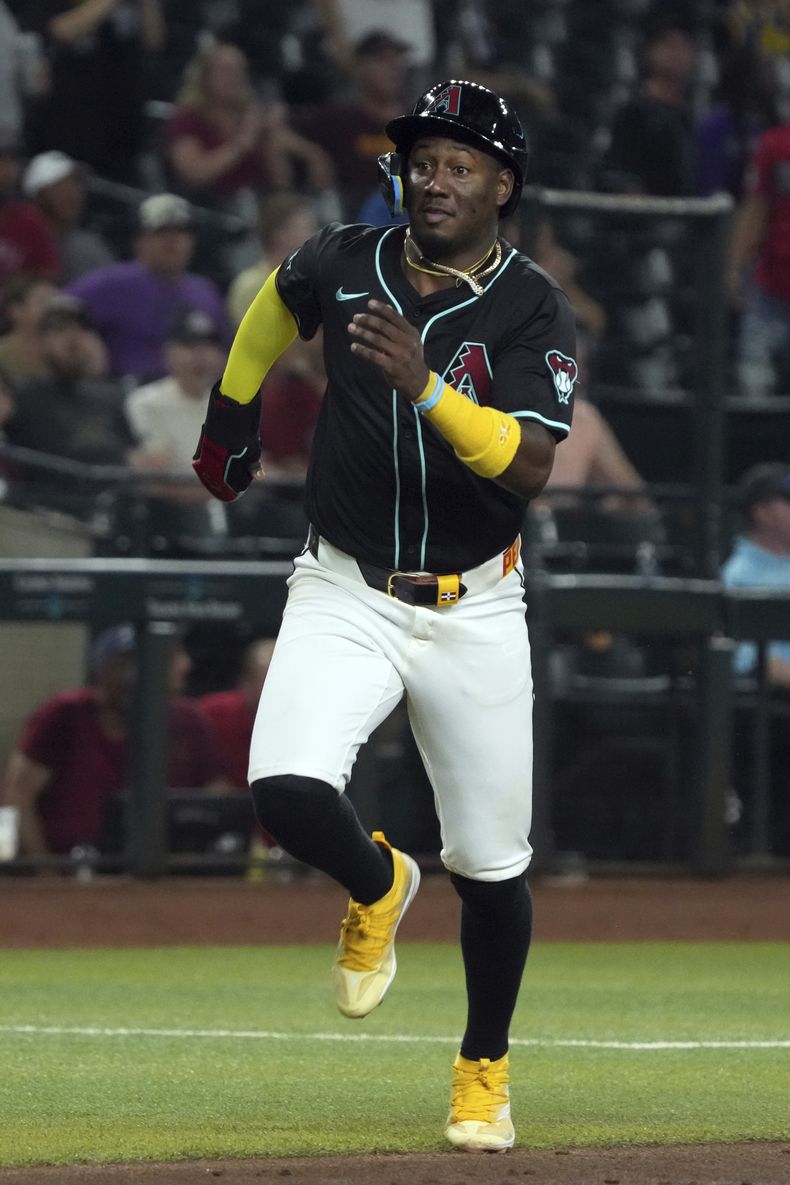 El dominicano Geraldo Perdomo, de los Diamondbacks de Arizona, anota en el séptimo inning del juego ante los Bravos de Atlanta, el miércoles 10 de julio de 2024 (AP Foto/Rick Scuteri)