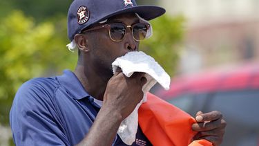 Donnay Wright, quien trabaja en un estacionamiento, se limpia el sudor del rostro mientras trabaja afuera del Minute Maid Park antes de un partido de béisbol entre los Rojos de Cincinnati y los Astros de Houston el sábado 17 de junio de 2023, en Houston. (AP Foto/David J. Phillip)
