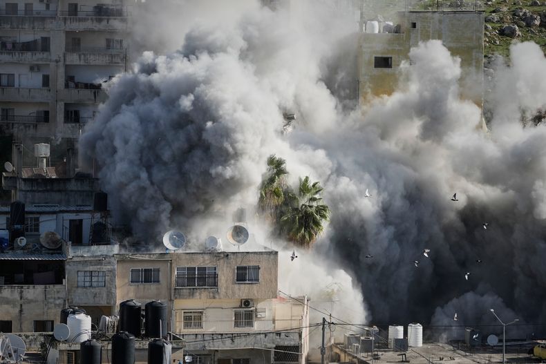 Una humareda se eleva mientras fuerzas israelíes derriban la casa de Abdul Karim Sanoubar, un supuesto miliciano palestino acusado por Israel de colocar bombas en autobuses en el centro de Israel, en Nablus, Cisjordania, el martes 2 de diciembre de 2025. (AP Foto/Majdi Mohammed)