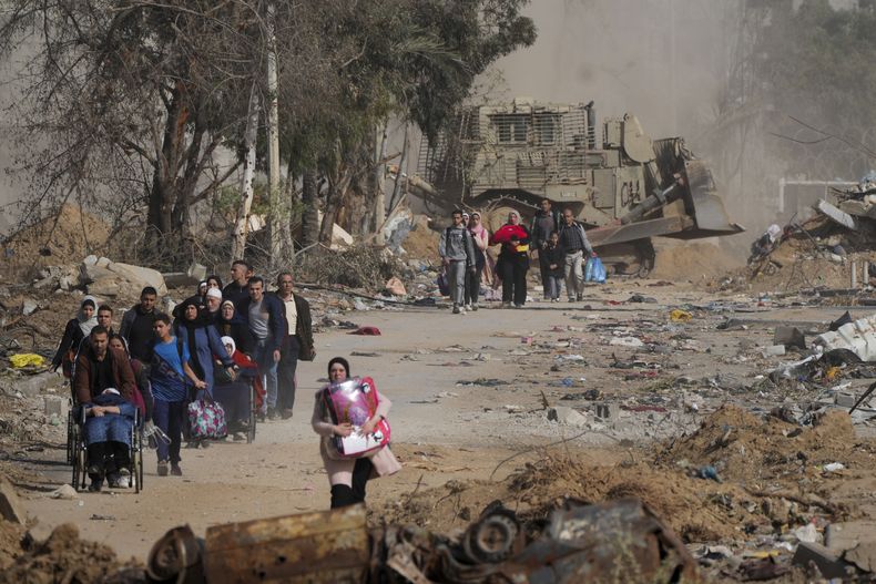 Palestinos huyen al sur en el tercer día de un cese el fuego entre Israel y Hamás en la carretera de Salah al-Din, en el centro de la Franja de Gaza, el 26 de noviembre de 2023. (AP Foto/Hatem Moussa)