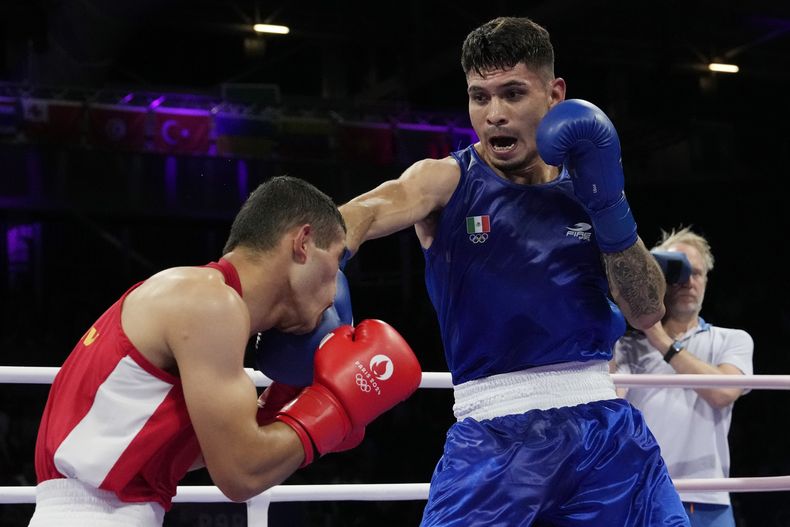 El mexicano Miguel Ángel Martínez golpea al uzbeko Ruslan Abdullaev en su combate de primera ronda en la categoría de 63,5 kilogramos de los Juegos Olímpicos, el lunes 29 de julio de 2024, en Villepinte, Francia. (AP Foto/Ariana Cubillos)