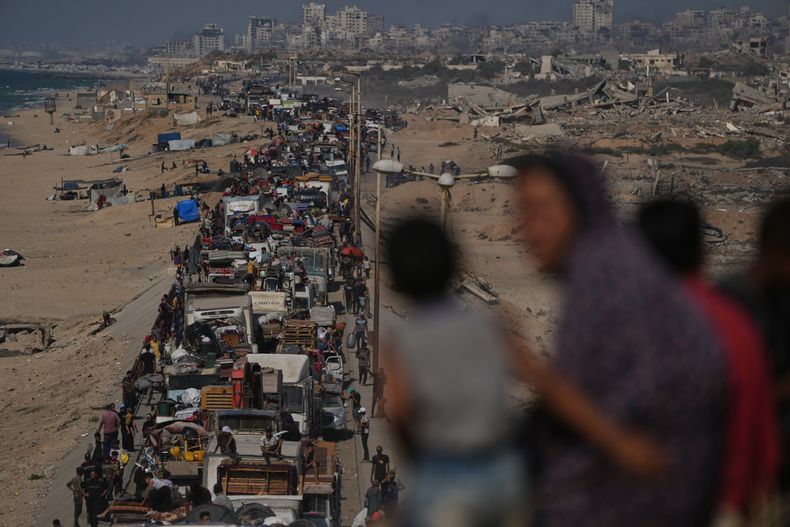 Palestinos desplazados huyen del norte de la Franja de Gaza, a pie y en vehículos, cargando sus pertenencias a lo largo de la carretera costera, cerca de Wadi Gaza, el martes 23 de septiembre de 2025. (AP Foto/Abdel Kareem Hana)