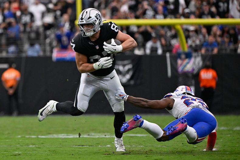 Michael Mayer (87), ala cerrada de los Raiders de Las Vegas, atrapa un pase y busca escapar de C.J. Gardner-Johnson (22), de los Bills de Buffalo, durante el partido de la NFL del domingo 18 de octubre de 2026, en Las Vegas. (AP Foto/David Becker)