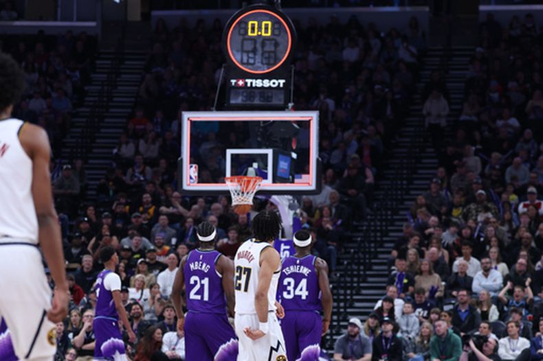 Jamal Murray (27), de los Nuggets de Denver, encesta un triple desde media cancha que superó a la bocina al final del primer cuarto del juego de baloncesto de la NBA en contra del Jazz de Utah, el miércoles 1 de abril de 2026, en Salt Lake City. (AP Foto/Rob Gray)