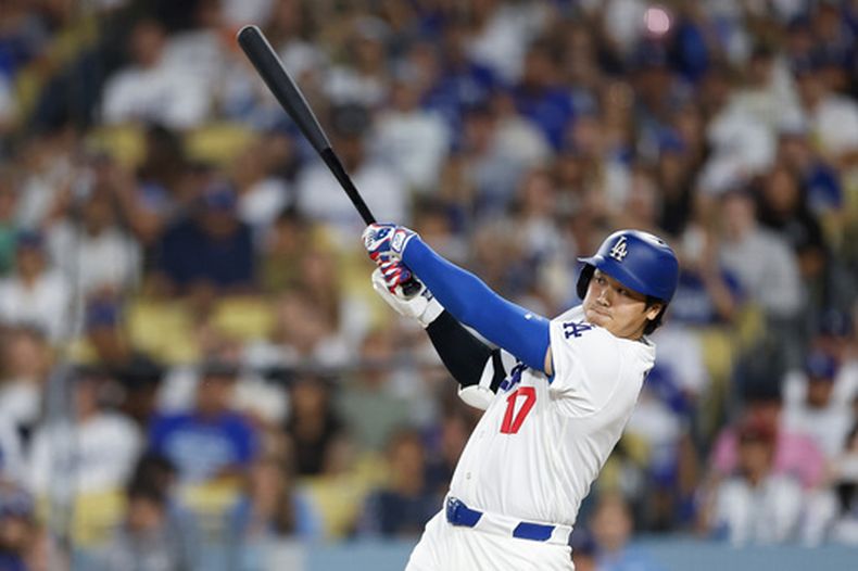 Shohei Ohtani (17), bateador designado de los Dodgers de Los Ángeles, batea un sencillo durante la séptima entrada del juego de béisbol de Grandes Ligas contra los Reales de Kansas City, el lunes 10 de agosto de 2026, en Los Ángeles. (AP Foto/Caroline Brehman)