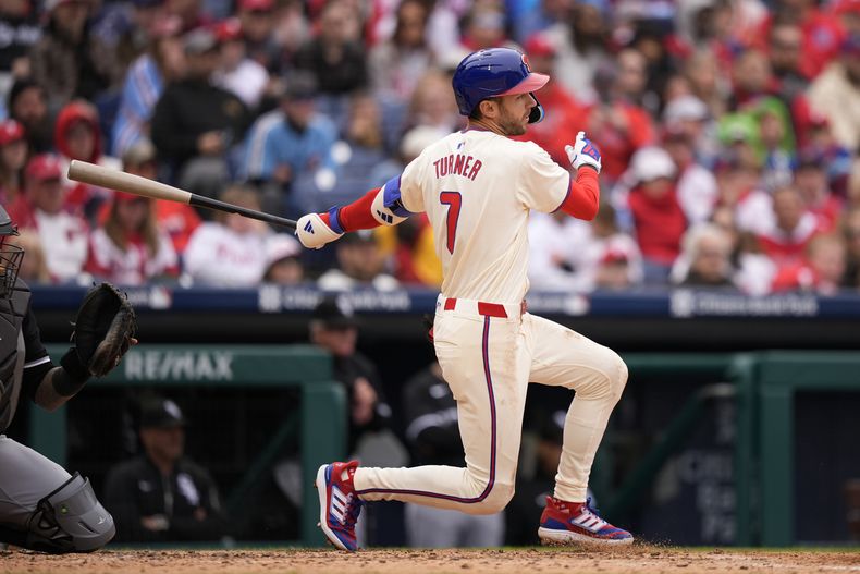 Trea Turner de los Filis de Filadelfia le da seguimiento a su sencillo con anotación en la cuarta entrada frente al pitcher de los Medias Blancas de Chicago Nick Nastrini el domingo 21 de abril del 2024. (AP Foto/Matt Slocum)