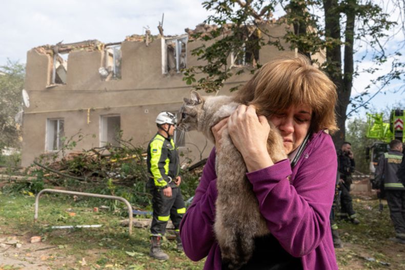 Una mujer abraza a su gato tras encontrarlo durante las labores de rescate y búsqueda en un edificio residencial dañado por un ataque de misiles rusos en Járkiv, Ucrania, el sábado 20 de junio de 2026. (AP Foto/Andrii Marienko)