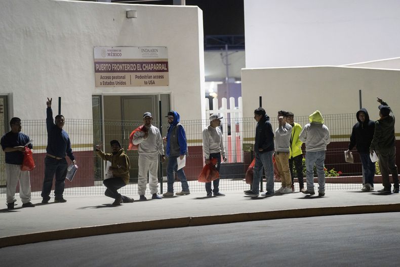 Migrantes deportados desde Estados Unidos, en el puente peatonal fronterizo de El Chaparral, en Tijuana, México, el 21 de enero de 2025. (AP Foto/Félix Márquez)