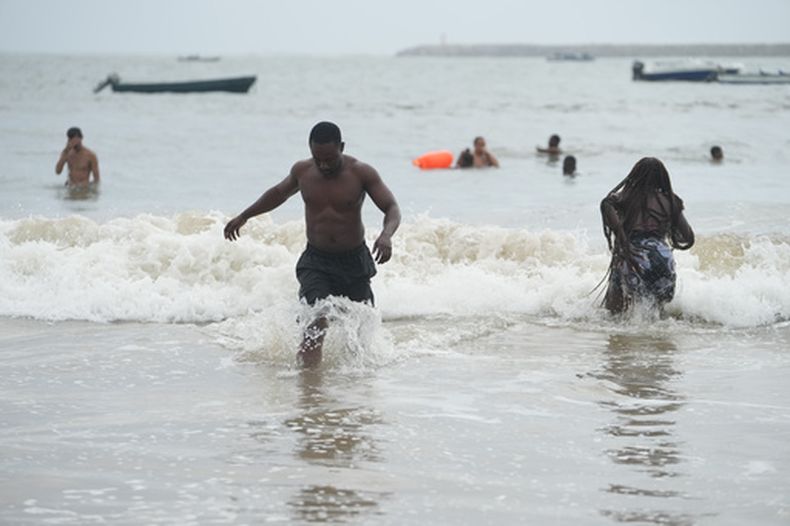 Mukthar Oladunmade, un escritor de 27 años, juega en el agua en la playa de Takwa Bay, en Lagos, Nigeria, el 28 de junio de 2026. (AP Foto/Sunday Alamba)