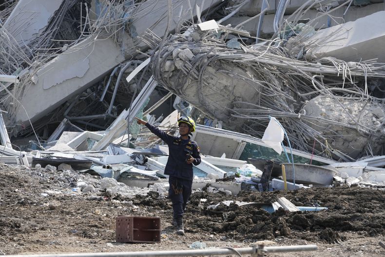 Un rescatista da instrucciones el sábado 29 de marzo de 2025 en el sitio donde un rascacielos que estaba en construcción colapso a causa de un sismo, en Bangkok, Tailandia. (AP Foto/Manish Swarup)