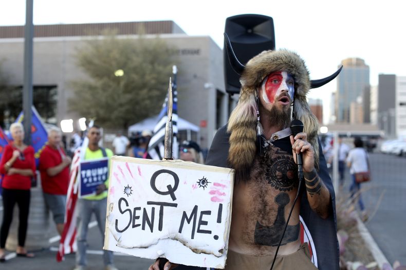 ARCHIVO - Jacob Anthony Chansley, que también se hace llamar Jake Angeli, creyente de Qanon, habla ante una multitud de partidarios del presidente Donald Trump fuera de la Oficina del Registrador del Condado de Maricopa, donde se cuentan los votos de la elección general, en Phoenix, Arizona, el 5 de noviembre de 2020. (AP Foto/Dario Lopez-Mills, Archivo)