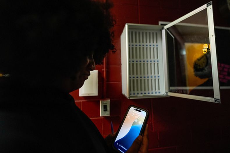ARCHIVO - Una estudiante revisa su celular en la escuela secundaria Ronald McNair, el 7 de agosto de 2025, en Atlanta. (AP Foto/Mike Stewart, archivo)