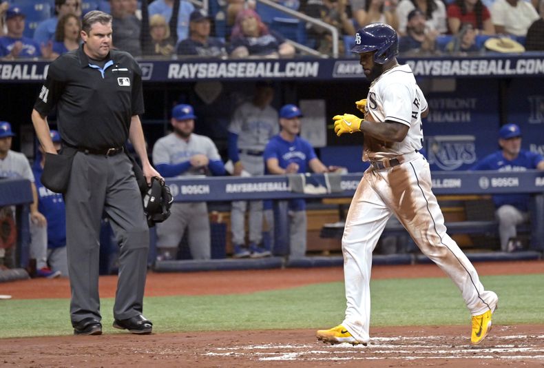 El umpire Jordan Baker observa a Randy Arozarena de los Rays de Tampa tras anotar desde la tercera base en la segunda entrada del juego ante los Azulejos de Toronto el lunes 22 de mayo del 2023. (AP Foto/Steve Nesius)