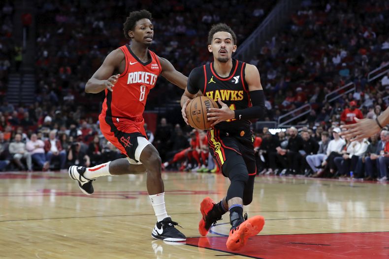 Trae Young, base de los Hawks de Atlanta, avanza a la cesta frente a JaeSean Tate, de los Rockets de Houston, durante la primera mitad del partido del miércoles 20 de diciembre de 2023 (AP Foto/Michael Wyke)