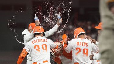 Joc Pederson, de los Gigantes de San Francisco, es felicitado por sus compañeros tras recibir un boleto con las bases llenas, para vencer a los Padres de San Diego, el martes 20 de junio de 2023 (AP Foto/Jeff Chiu)