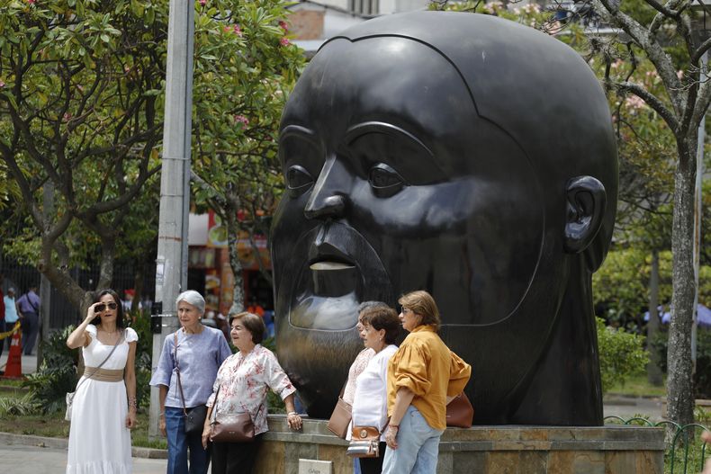 Personas posan para retratos frente a una escultura del artista colombiano Fernando Botero en el Parque Botero en Medellín Colombia, el viernes 15 de septiembre de 2023. El reconocido pintor y escultor colombiano Fernando Botero falleció viernes a los 91 años. (Foto AP/Jaime Saldarriaga)