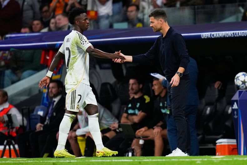 El técnico del Real Madrid Xabi Alonso estrecha la mano de Vinícius Júnior durante el partido contra Juventus en la Liga de Campeones, el miércoles 22 de octubre de 2025, en Madrid. (AP Foto/Manu Fernández)