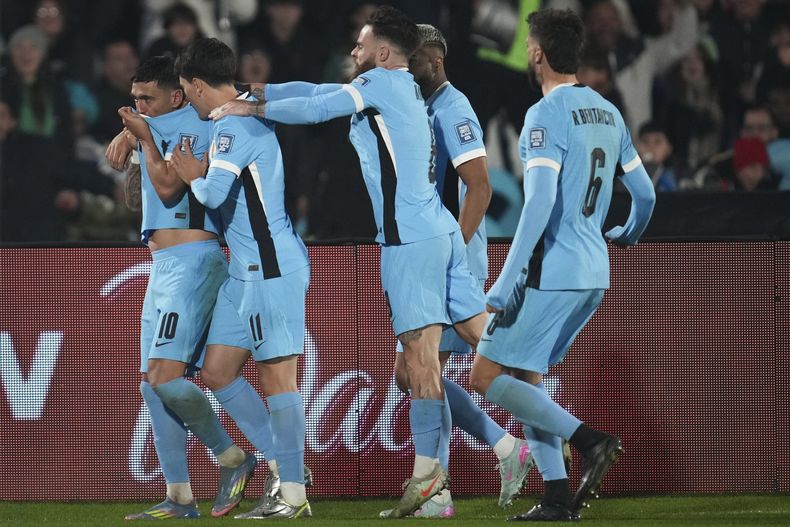 Giorgian de Arrascaeta (izquierda) festeja con sus compañeros de la selección de Uruguay luego de anotar ante Venezuela en el encuentro de la eliminatoria mundialista disputado el martes 10 de junio de 2025 (AP Foto/Matilde Campodonico)