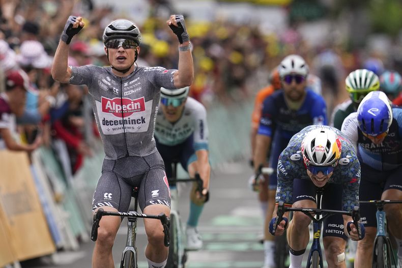 El belga Jasper Philipsen celebra al cruzar la línea de meta frente a Wout van Aert y Pascal Ackermann para ganar la 13ma etapa del Tour de Francia en Pau, Francia el viernes 12 de julio del 2024. (AP Foto/Daniel Cole)