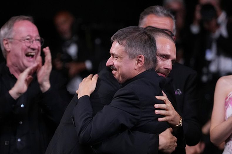 Sebastian Stan, izquierda, abraza a Cristian Mungiu, ganador de la Palma de Oro por “Fjord”, en la ceremonia de entrega de premios del 79no Festival Internacional de Cine de Cannes, en el sur de Francia, el sábado 23 de mayo de 2026. (AP Foto/Andreea Alexandru).
