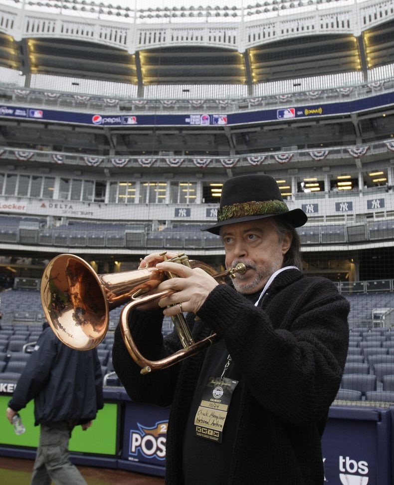 ARCHIVO - El fliscornista Chuck Mangione ensaya el himno nacional antes de un partido de béisbol entre los Angelinos de Los Ángeles y los Yankees de Nueva York, el 24 de octubre de 2009, en Nueva York. (Foto AP/Elise Amendola, archivo)