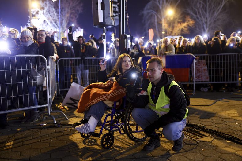 Gente sostiene sus celulares durante un minuto de silencio mientras bloquean un puente durante una protesta por el derrumbe de una cornisa de concreto que mató a varias personas hace más de dos meses en Novi Sad, Serbia, el domingo 2 de febrero de 2025. (AP Foto/Armin Durgut)
