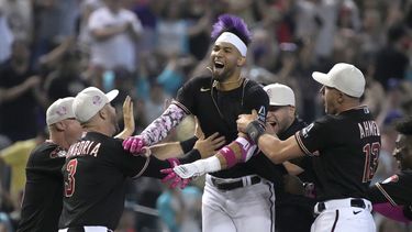 Lourdes Gurriel Jr., centro, de los Diamondbacks de Arizona, celebra con sus compañeros de equipo después de definir el partido de béisbol en contra de los Gigantes de San Francisco con un doble en la novena entrada, el domingo 14 de mayo de 2023, en Phoenix. (AP Foto/Rick Scuteri)