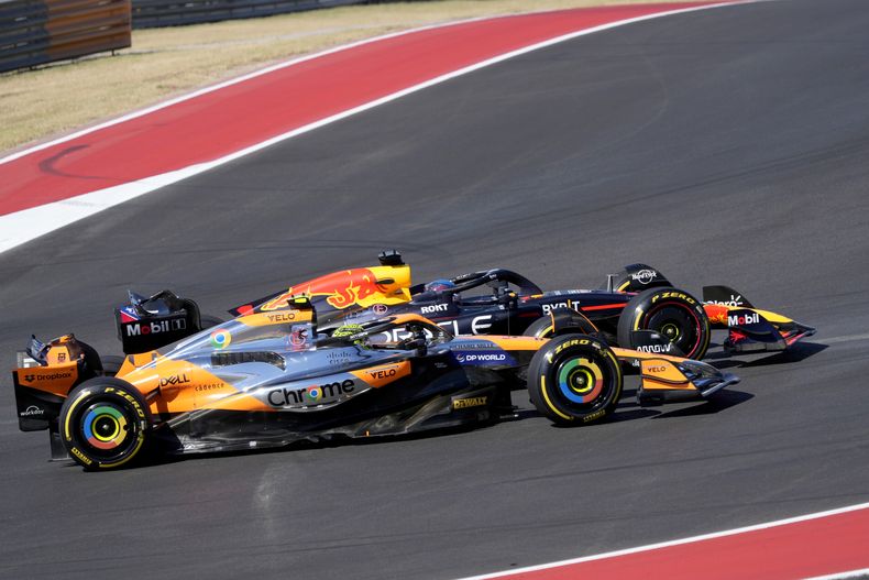 Lando Norris (McLaren) y Max Verstappen (Red Bull) atrás compiten durante la primera curva del Gran Premio de Estados Unidos, el domingo 20 de octubre de 2024, en Austin, Texas. (AP Foto/Eric Gay)