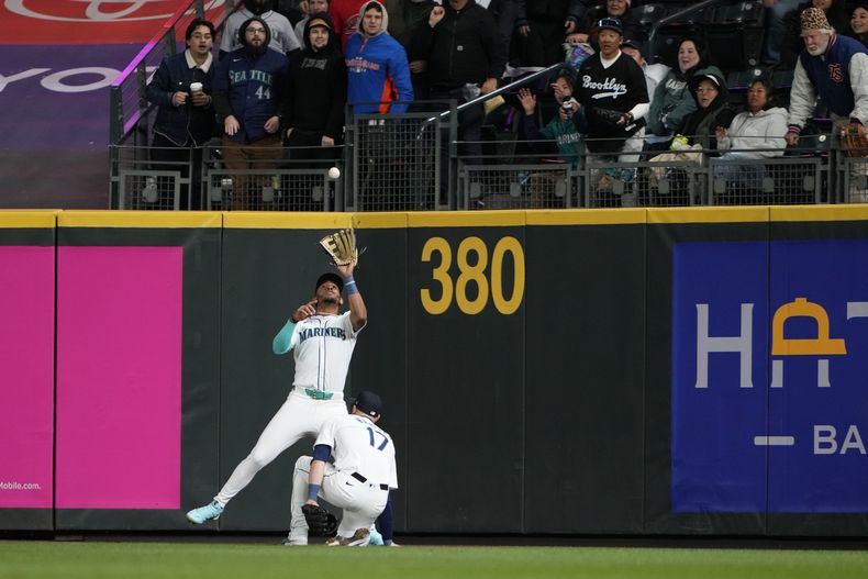 El dominicano Julio Rodríguez, de los Marineros de Seattle, atrapa un elevado en el juego ante los Rojos de Cincinnati, el martes 16 de abril de 2024 (AP Foto/Lindsey Wasson)