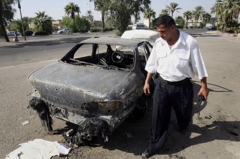 Un polic&iacute;a de tr&aacute;nsito iraqu&iacute; inspecciona un auto destruido por guardias de Blackwater en la Plaza al-Nisoor en Bagdad, Irak en una fotograf&iacute;a de archivo del 25 de septiembre de 2007.  En un relato de muerte y destrucci&oacute;
