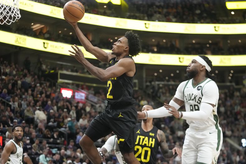 El base del Jazz de Utah Collin Sexton avanza con el balón hacia la canasta mientras lo defiende el alero de los Bucks de Milwaukee Jae Crowder en el encuentro de la NBA del domingo 4 de febrero del 2024. (AP Foto/Rick Bowmer)