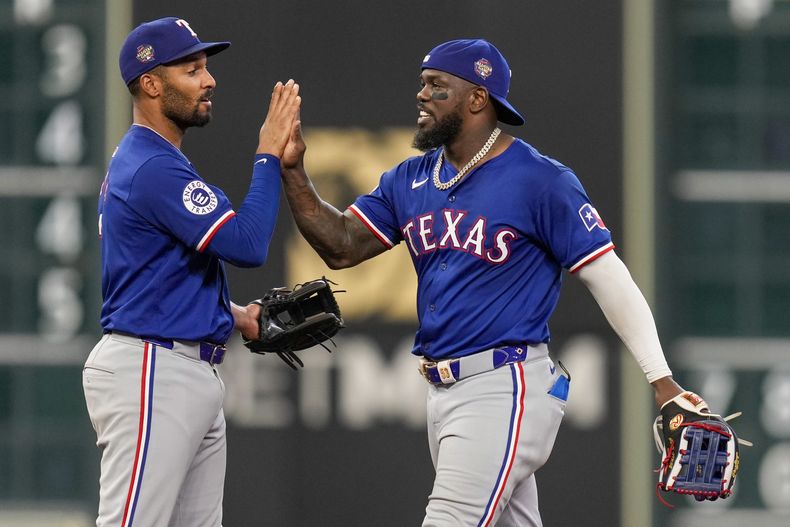Adolis García, de los Rangers de Texas, a la derecha, celebra con Marcus Semien después de una victoria sobre los Astros de Houston el sábado 13 de julio de 2024, en Houston. (AP Foto/Eric Christian Smith)