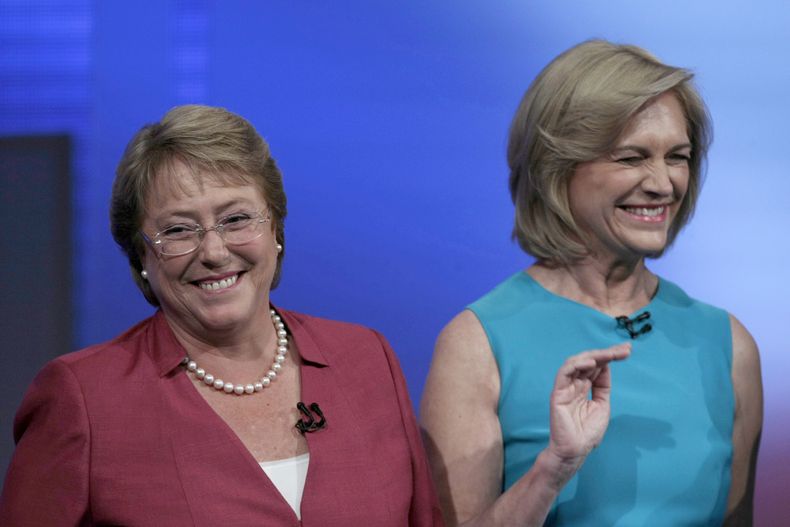 Las candidatas presidenciales chilenas Michelle Bachelet, izquierda, y Evelyn Matthei, derecha, sonr&iacute;en antes de que comience un debate en una televisora de Santiago, el martes 29 de octubre de 2013. Los chilenos consideran m&aacute;s grave tirar b
