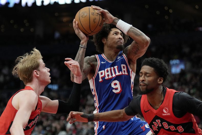 Kelly Oubre Jr. (9), de los 76ers de Filadelfia, se cuela entre Kobi Simmons (8) y Gradey Dick (1), de los Raptors de Toronto, durante la segunda mitad del juego de baloncesto de la NBA, el domingo 31 de marzo de 2024, en Toronto. (Frank Gunn/The Canadian Press vía AP)