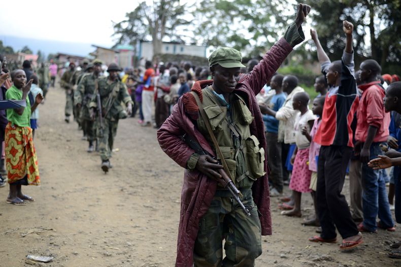 Un soldado del ej&eacute;rcito congole&ntilde;o saluda a los civiles que lo aclaman mientras el ej&eacute;rcito entra en el poblado de Bunagana, en el este de Congo, cerca de la frontera con Uganda, el mi&eacute;rcoles 30 de octubre de 2013.  (AP Foto/Jos