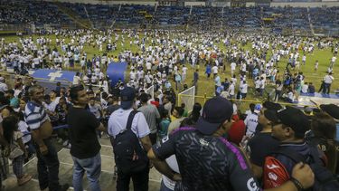 Hinchas en el campo del estadio Cuscatlán en San Salvador, El Salvador, el sábado 20 de mayo de 2023. Doce personas murieron y más de 100 resultaron lesionadas tras una estampida cuando la gente intentó derribar una puerta de acceso. (AP Foto/Milton Flores)