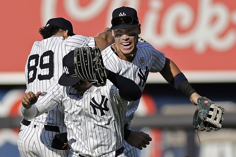 El jardinero central de los Yankees de Nueva York, Aaron Judge (derecha) celebra junto a Juan Soto (frontal) y Jasson Domínguez (89) luego del juego de béisbol ante los Medias Rojas de Boston, el domingo 15 de septiembre de 2024, en Nueva York. (AP Foto/Adam Hunger)
