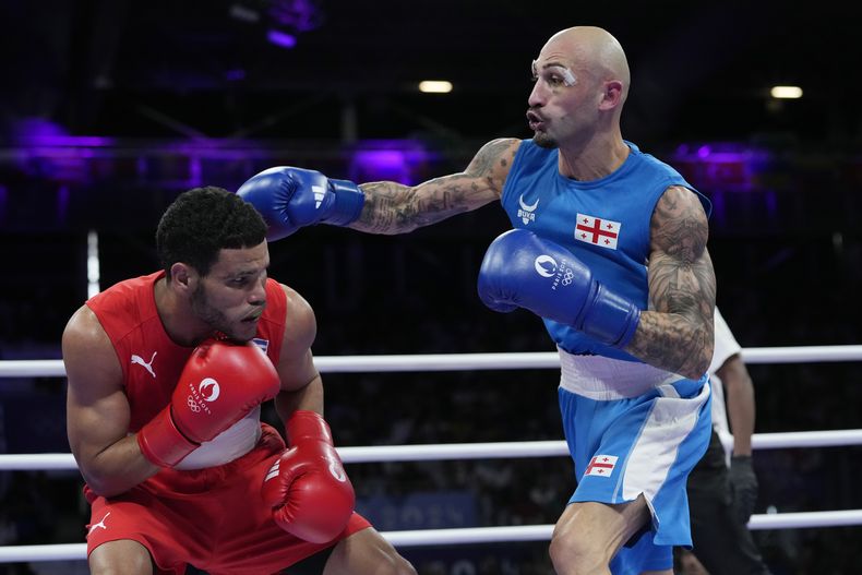 El cubano Erislandy Álvarez, de rojo, en su semifinal de peso ligero de Juegos Olímpicos ante el georgiano Lasha Guruli, el domingo 4 de agosto de 2024, en Villepinte, Francia. (AP Foto/Ariana Cubillos)