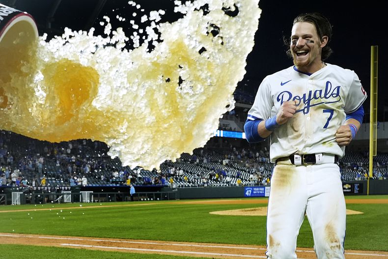 Bobby Witt Jr., de los Reales de Kansas City, busca evitar que lo empapen con el contenido de la hielera, tras la victoria sobre los Tigres de Detroit, el martes 21 de mayo de 2024 (AP Foto/Charlie Riedel)