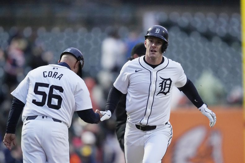 Mark Canha, de los Tigres de Detroit, es felicitado por el coach de la antesala Joey Cora, luego de batear un jonrón en el encuentro del viernes 12 de abril de 2024, ante los Mellizos de Minnesota (AP Foto/Carlos Osorio)