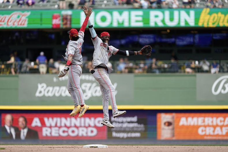 Elly De La Cruz, de los Rojos de Cincinnati, a la derecha, celebra con Santiago Espinal (4) después de vencer a los Cerveceros de Milwaukee, el domingo 11 de agosto de 2024, en Milwaukee. (AP Foto/Aaron Gash)