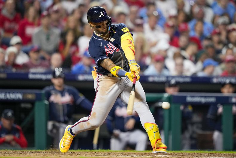 El venezolano Ronald Acuña Jr., de los Bravos de Atlanta, batea un sencillo en el tercer juego de la Serie Divisional de la Liga Nacional ante los Filis de Filadelfia, el miércoles 11 de octubre de 2023 (AP Foto/Matt Slocum)
